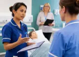 International nurse performing an SBAR handover during an NMC OSCE evaluation in a UK clinical simulation room